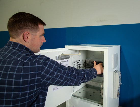 Caleb putting battery on charge with cabinet