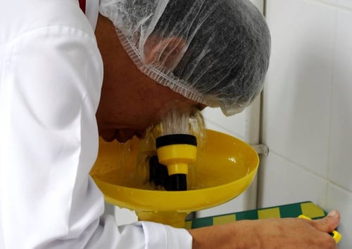 worker flushing his eyes at an eyewash station