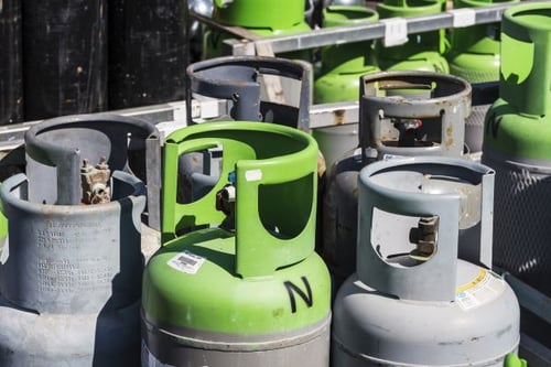 high pressure industrial gas cylinders stored in metal cages outdoor