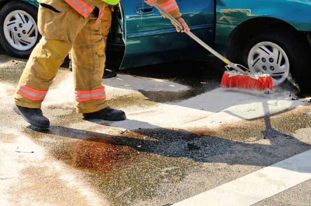 worker using absorbents to clean up the chemical spillage from the truck