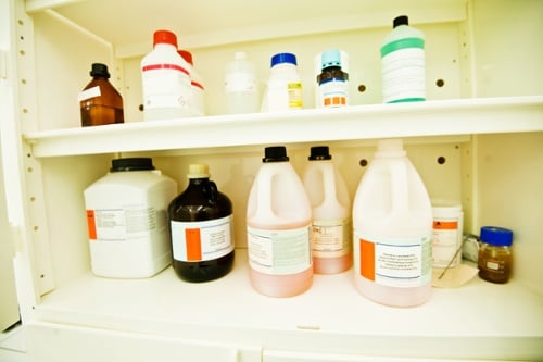 toxic chemical bottles in lab cabinet
