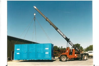 red truck lifting a blue container