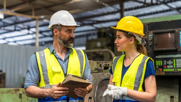 two staff in ppe discussing work matters-1